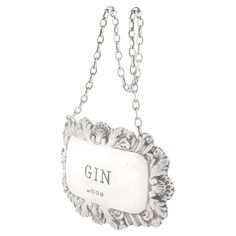 a silver plate hanging from a chain with the word gin on it's side