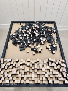 a large group of wooden blocks sitting on top of a black and white floor next to a wall