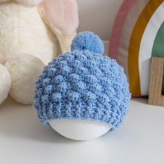 a crocheted hat sitting next to a stuffed animal