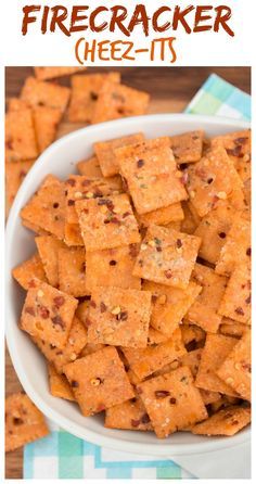 a white bowl filled with cheesy crackers on top of a table