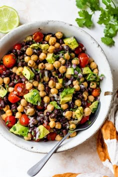 a white bowl filled with black eyed peas, avocado, tomatoes and cilantro