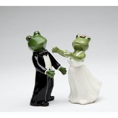 two frog figurines dressed in black and white, one holding the other's hand