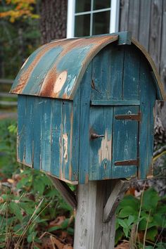 an old blue mailbox sitting in the grass