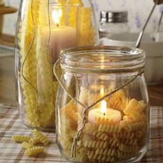 two jars filled with pasta and lit candles