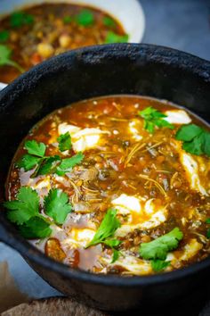 two bowls filled with soup and garnished with cilantro