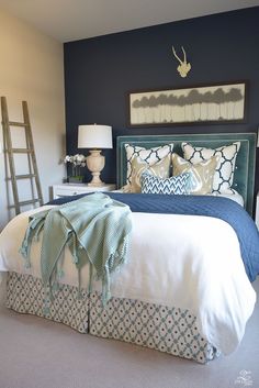 a bedroom with blue walls and white bedding