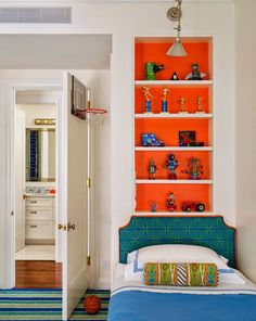 a bedroom with an orange book shelf above the bed