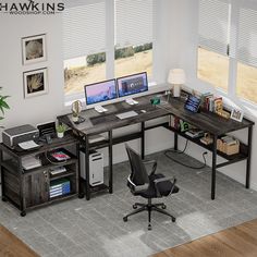 a computer desk with two monitors and a printer on it in front of windows that look out onto a field