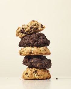 chocolate chip cookies stacked on top of each other in front of a white background,