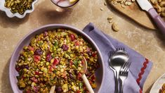 a bowl full of food with spoons next to it