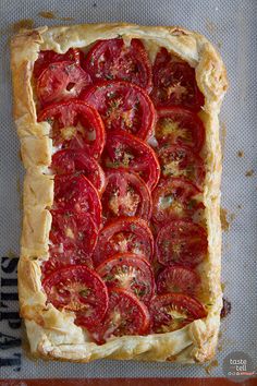 an overhead view of a tomato tart on a baking sheet with the crust removed