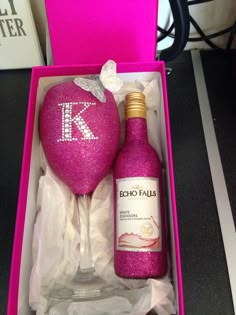 a pink wine glass and bottle in a box