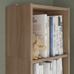 a book shelf with several books on it and a stuffed animal in the bottom corner