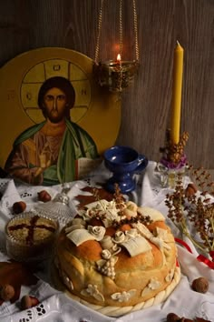 a table topped with bread next to a candle and other items on top of it