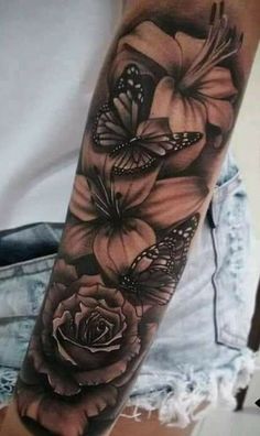 a woman's arm with flowers and butterflies on it