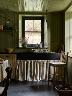 a kitchen with green walls and black counter tops, an old fashioned sink and wooden cabinets