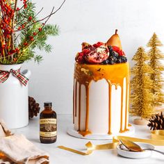 there is a cake decorated with pomegranates and christmas decorations on the table