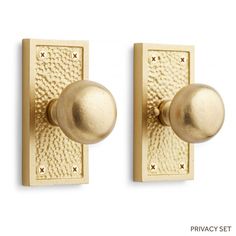 two brass door knobs on a white background