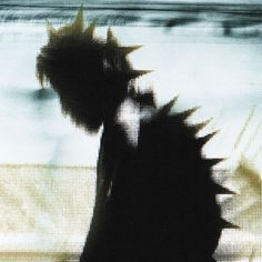 the silhouette of a person with spikes on their head is shown in front of a window