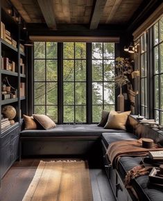 a living room filled with lots of furniture next to a large window covered in bookshelves