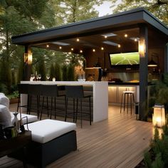 an outdoor bar with stools and lights on the outside patio, next to trees