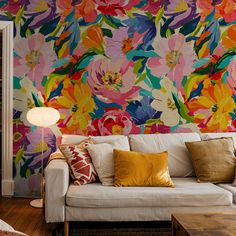 a living room with floral wallpaper and white couches in front of a colorful flowered wall