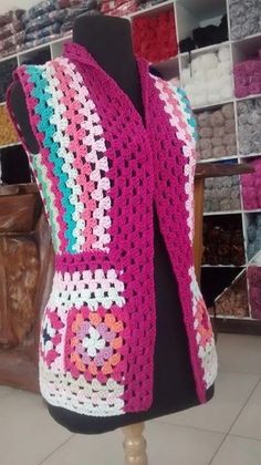 a pink crocheted shawl on a mannequin in front of a store display