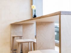 three white stools sitting in front of a counter