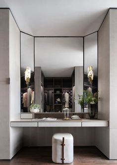 a dressing room with mirrors, stools and lights on the wall next to it