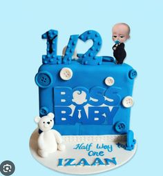 a baby's first birthday cake is decorated in blue and white with a teddy bear