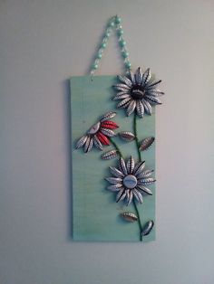 a flower is hanging on the wall with beads