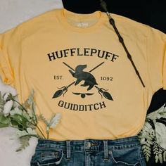 a yellow t - shirt with the words hufflepuff quidditch on it