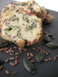 two pieces of cake sitting on top of a table next to some nuts and seeds