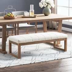 a wooden table with two benches in front of it and a vase on the side