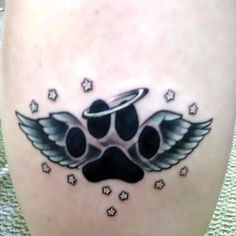 a dog's paw with an angel halo and stars tattoo on the leg,