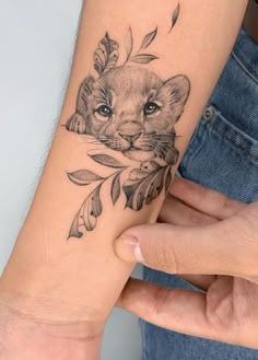 a woman's arm with a tattoo on it and an image of a lion