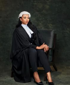 a woman sitting on top of a chair wearing a black dress and white head scarf