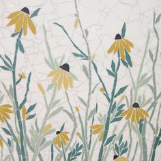 yellow flowers and green leaves painted on a white wall with cracked glass behind them