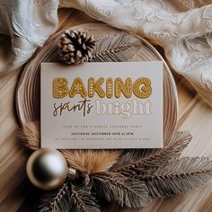 a card with the words baking starts bright on it next to christmas decorations and pine cones