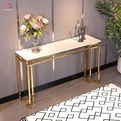 a white and gold console table with flowers on top