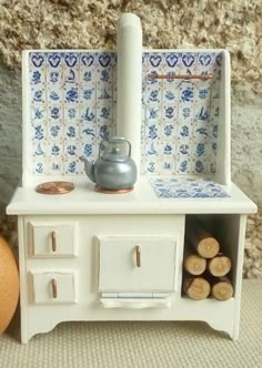 a doll house kitchen with an egg in the foreground and a stove on the far side