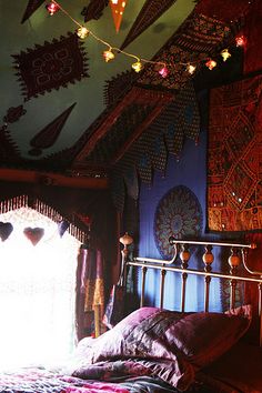 a bed in a room with lights strung from the ceiling and curtains on the wall