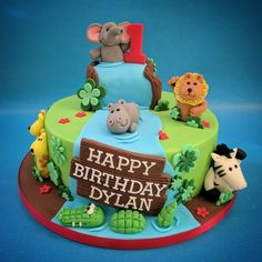 a birthday cake decorated with animals and a sign