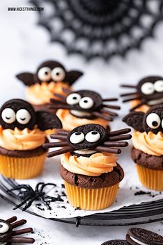 chocolate cupcakes decorated with oreos and sprinkles are on a plate