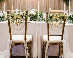 the chairs are decorated with greenery and monogrammed signs for their wedding reception