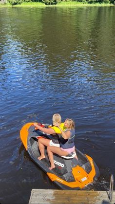 two people on an orange and black jet ski