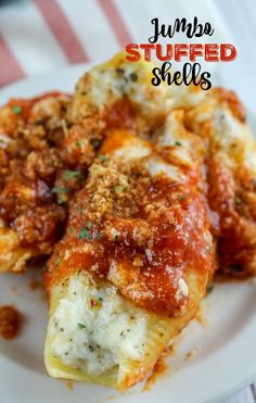 stuffed shells on a white plate with sauce and parmesan cheese in the middle