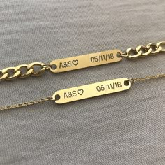 two personalized gold chain bracelets with names engraved on the side and heart charms attached to them