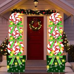 two christmas decorations on the front door of a house decorated with lights and candy canes