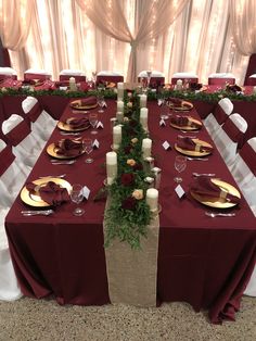 the table is set with red and white linens, gold plates and silverware